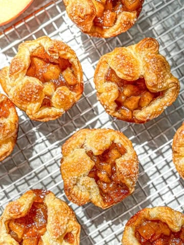 Baked apple croissants on a wire rack.