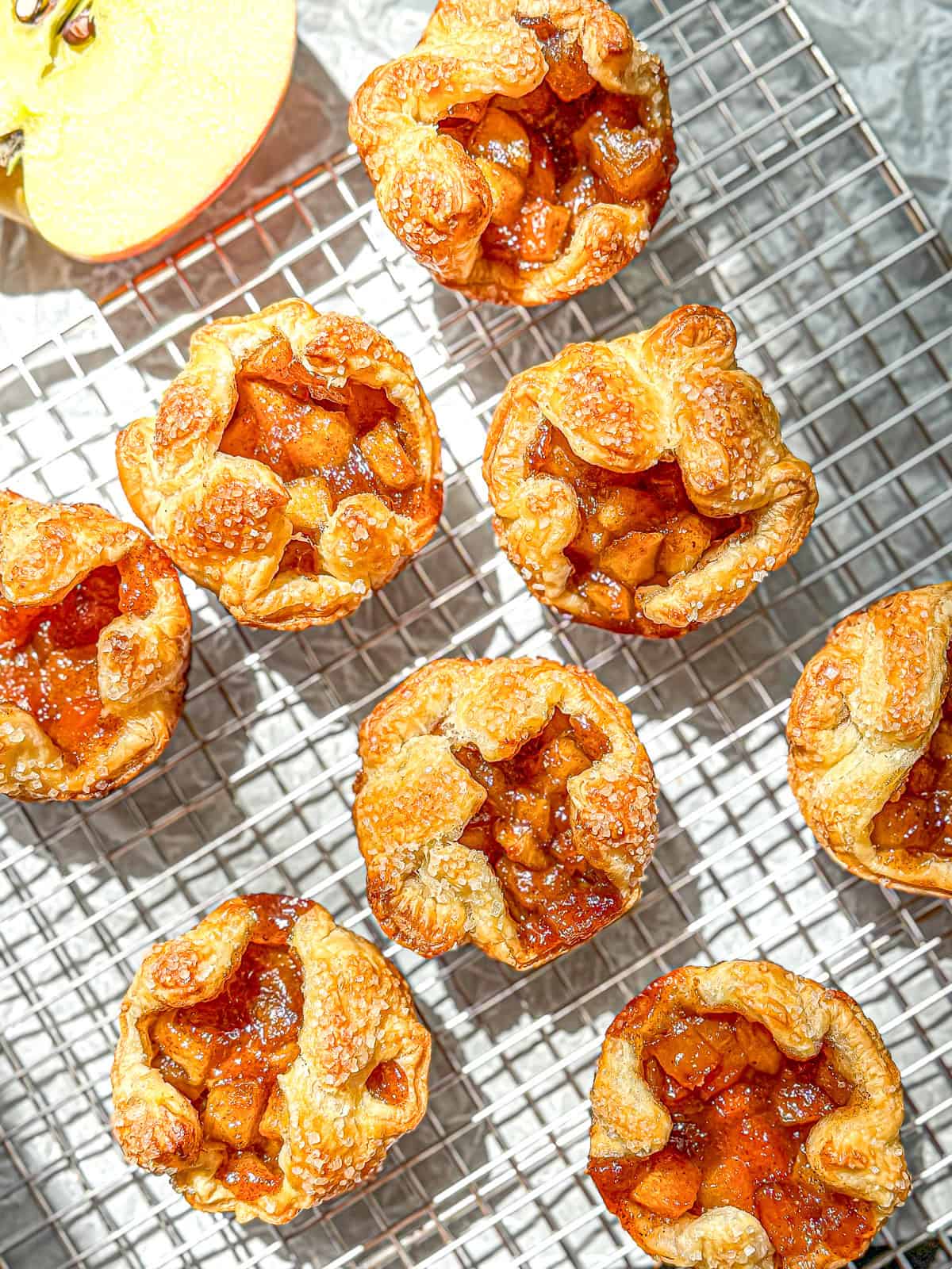 Baked apple croissants on a wire rack.
