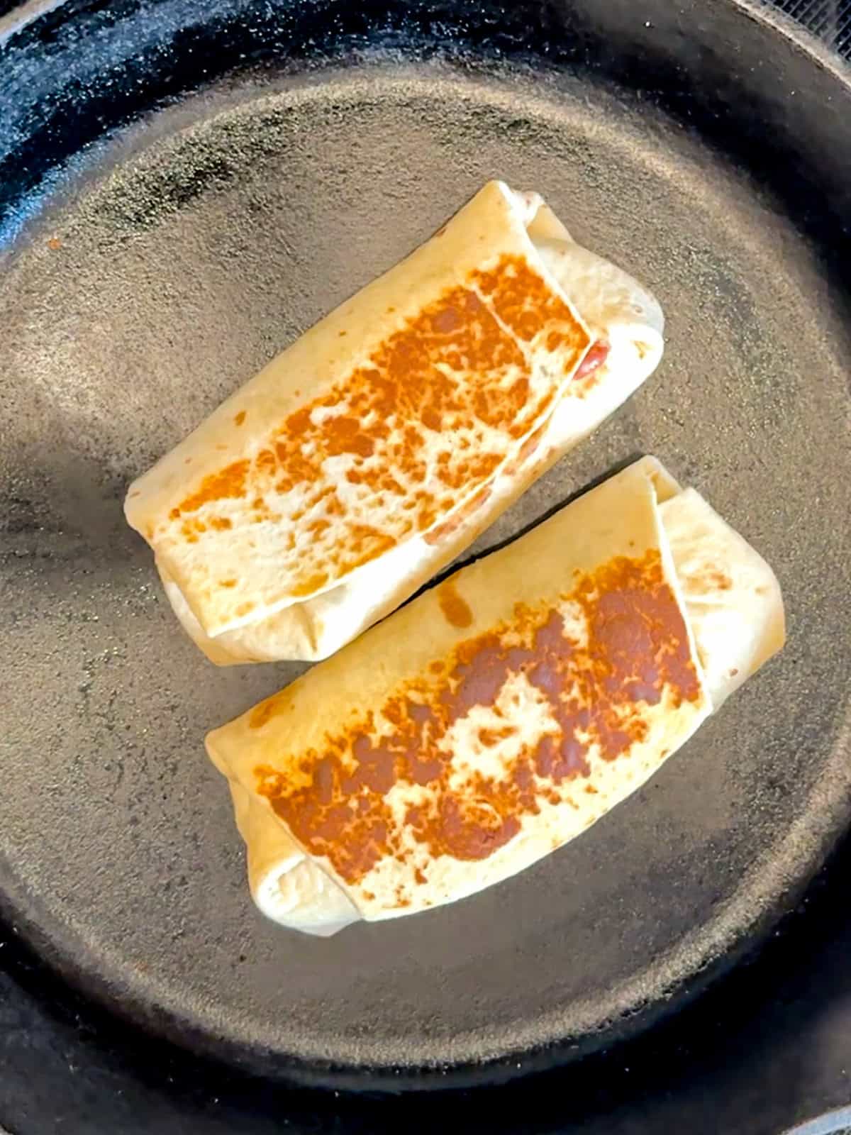 Griddling, bean and cheese burritos in a cast-iron pan to seal the same shot and give them a crispy surface.