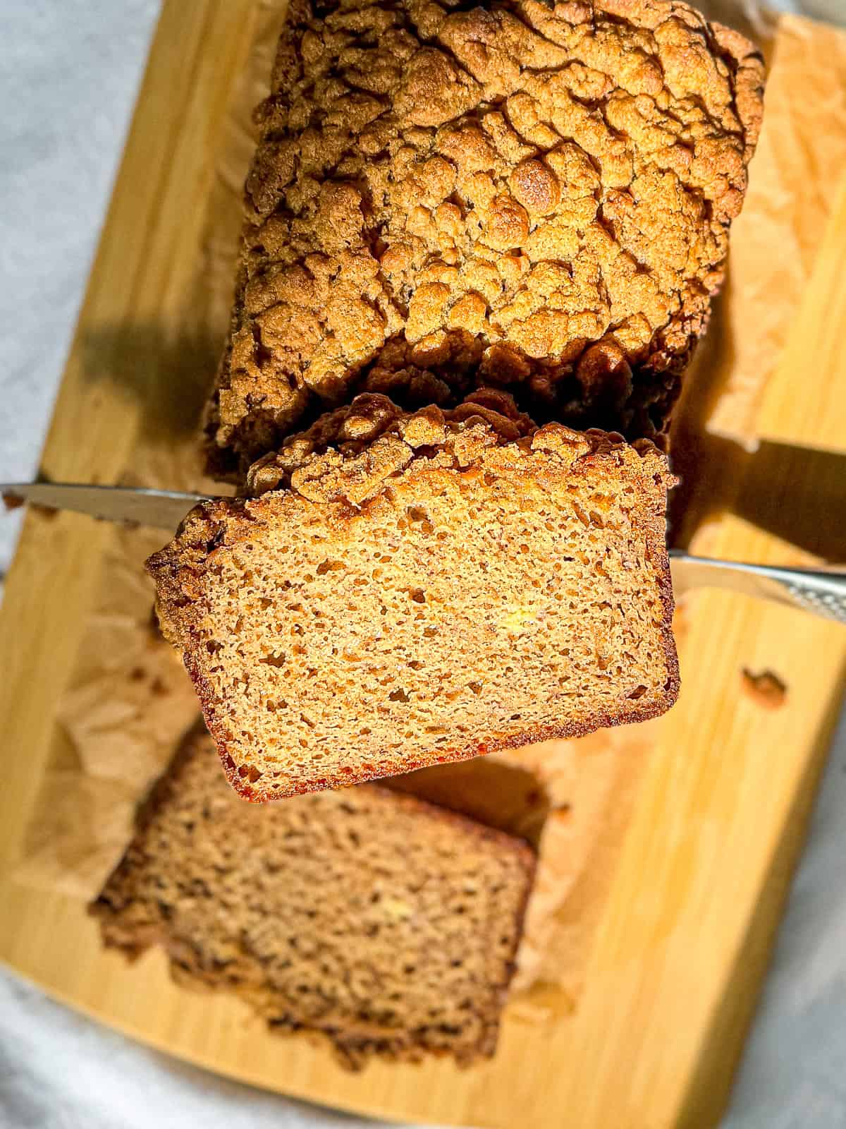 Pumpkin spice banana bread on a wood cutting board.