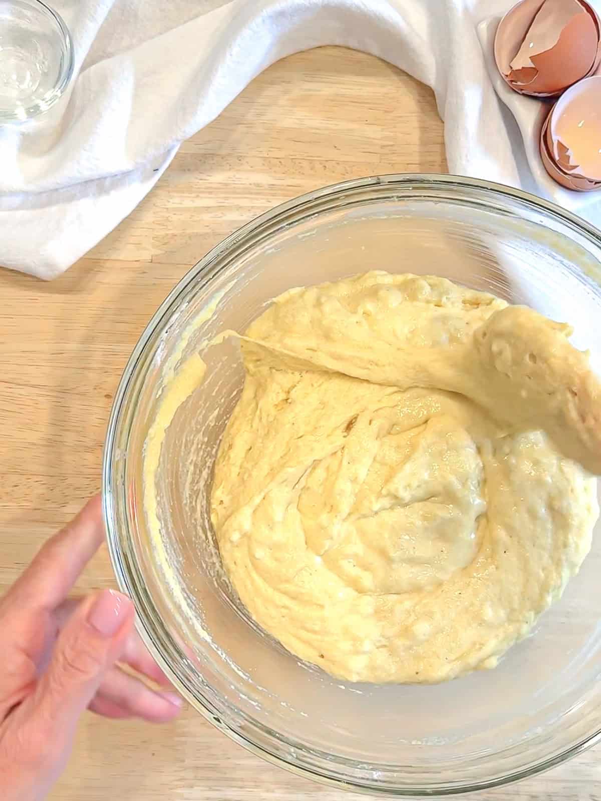 Mixing southern hoecake batter in a glass bowl.