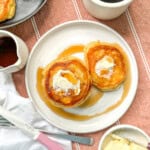 Southern hoecakes on a white plate with butter and maple syrup.