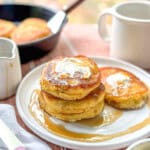 Southern hoecakes on a white plate with butter and maple syrup.