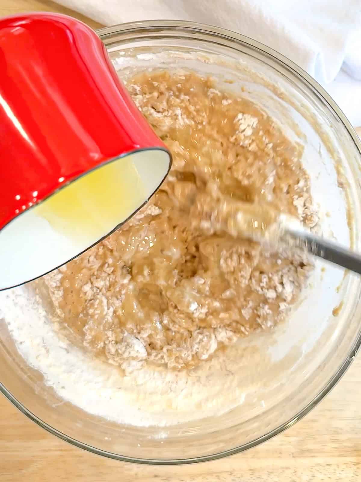 Mixing melted butter into apple cider donut batter.