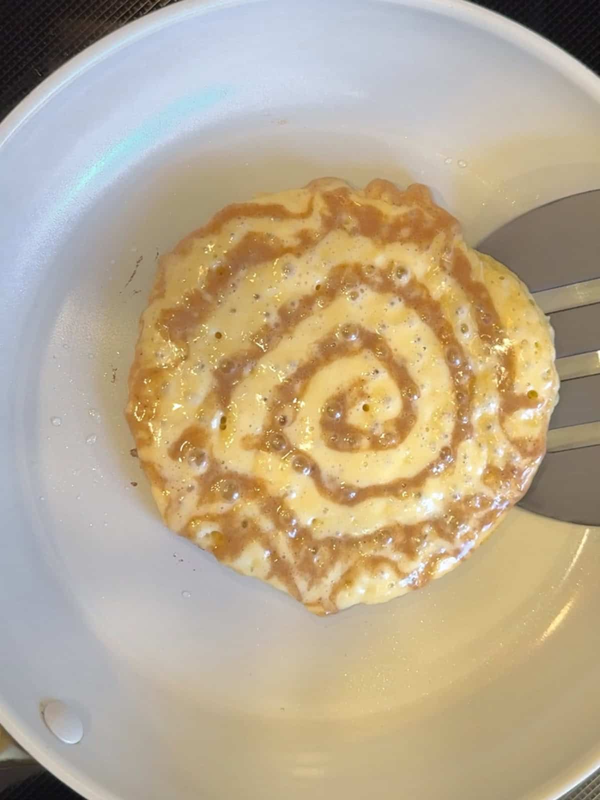 Getting ready to flip a cinnamon roll pancake.