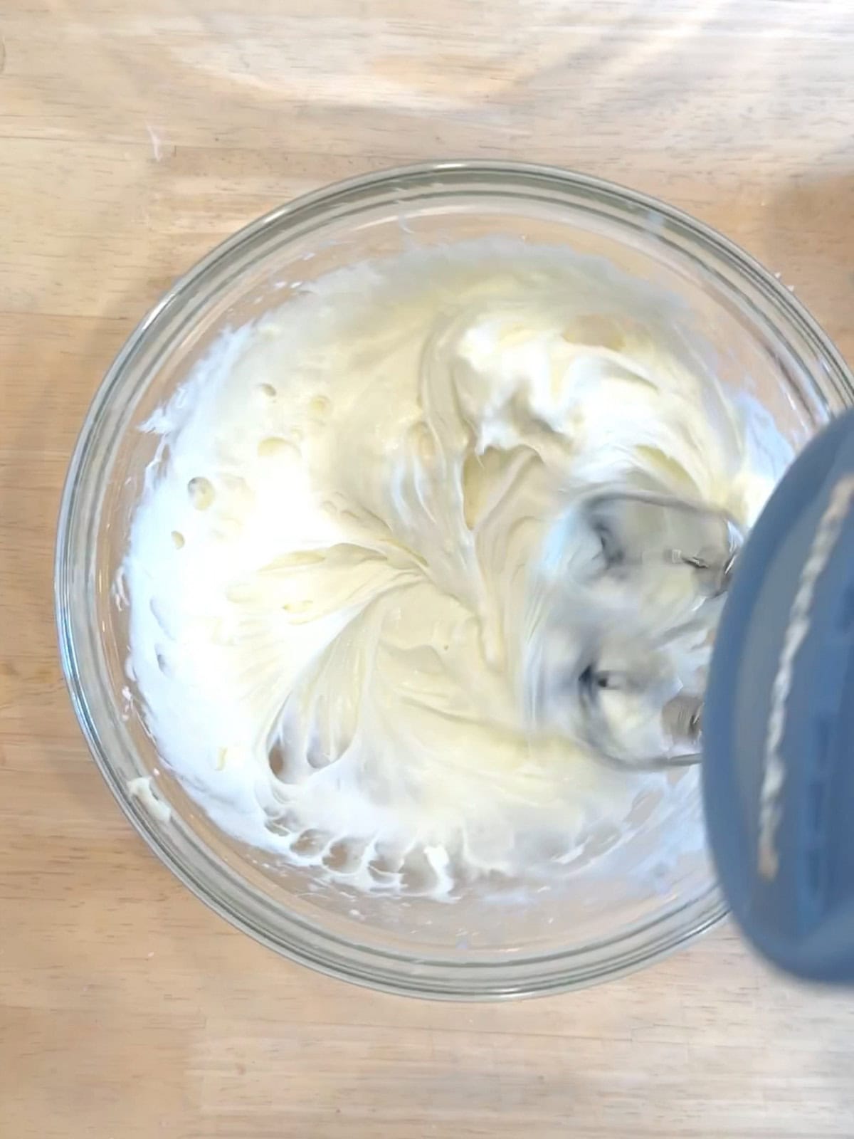 Using a hand mixer to make cream cheese glaze.