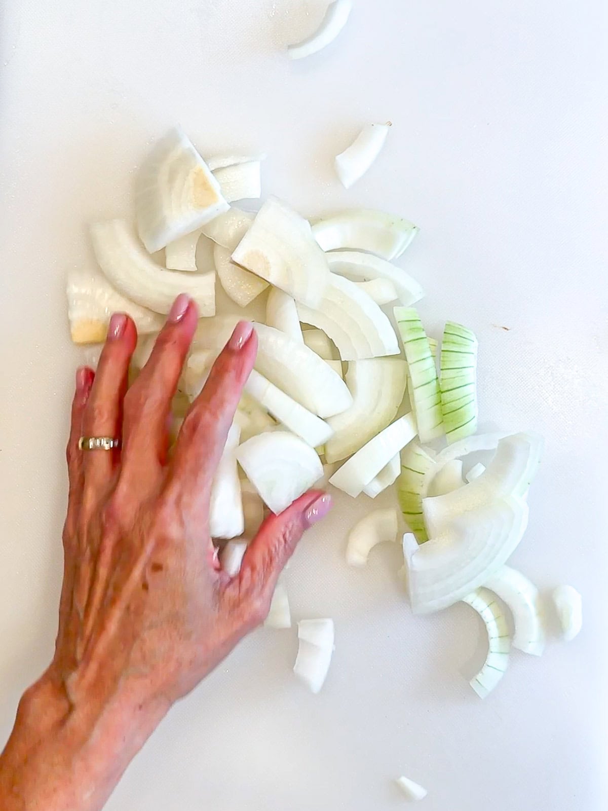 Chopped onion on a white cutting board.