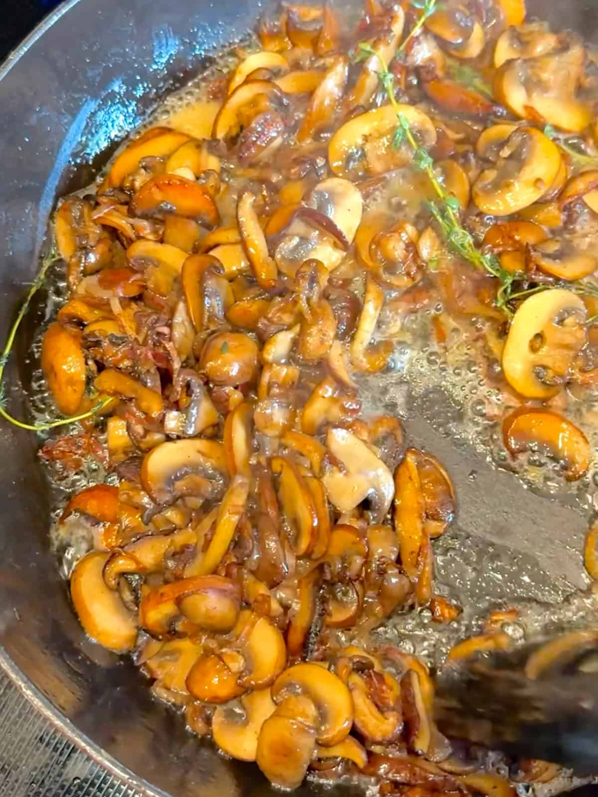 Sautéed mushrooms and shallots in a skillet.