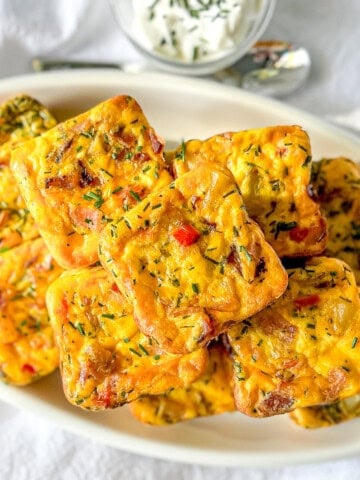 Potato cheddar and chive egg bites on a white platter.