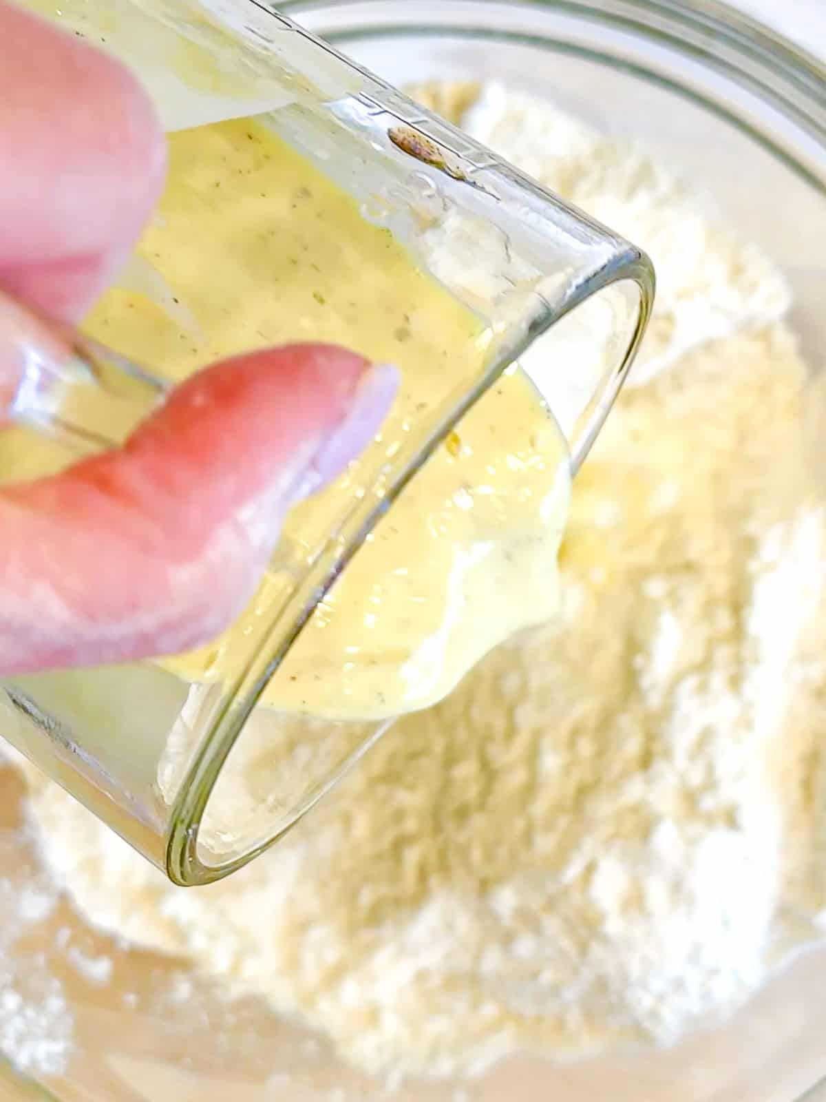 Adding wet ingredients to dry ingredients to make buttermilk scones.