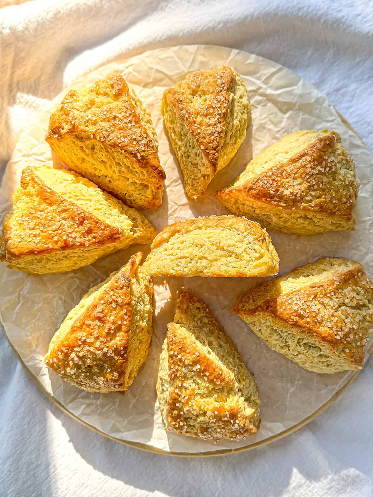 Buttermilk scones on a parchment paper line cutting board.