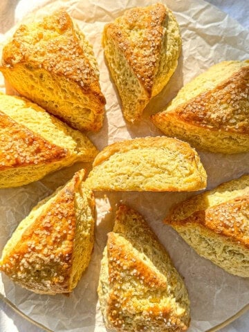 Buttermilk scones on a parchment paper line cutting board.