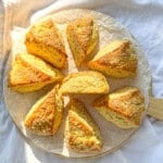 Buttermilk scones on a parchment paper line cutting board.