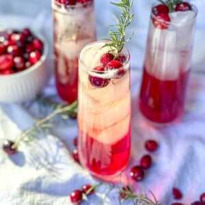 Cranberry mocktails with fresh cranberries and sprigs of rosemary.