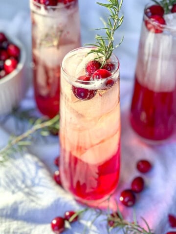 Cranberry mocktails with fresh cranberries and sprigs of rosemary.