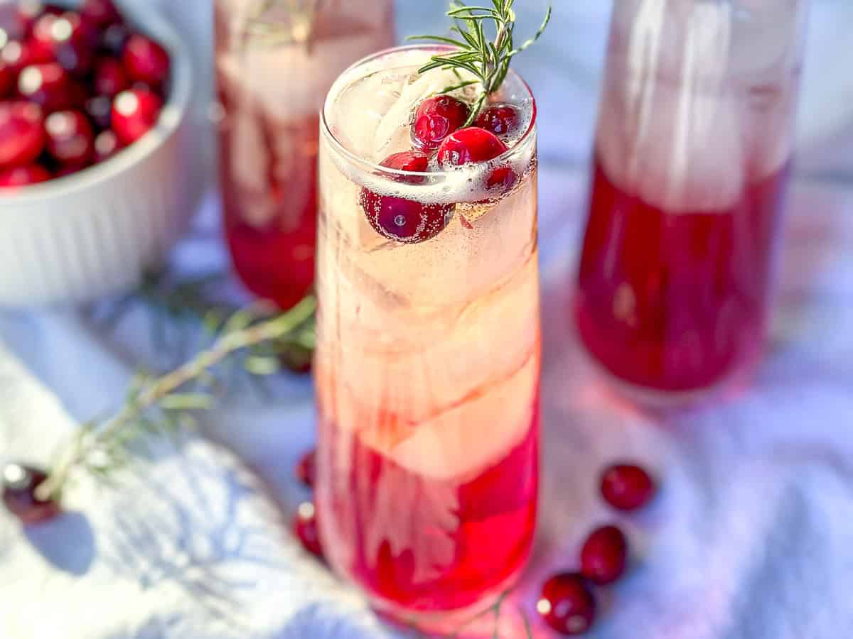 Cranberry mocktails with fresh cranberries and sprigs of rosemary.