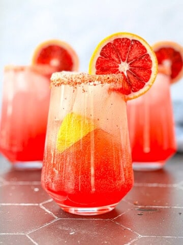 Angled view of a blood orange mimosa Mocktail with a blood orange garnish.