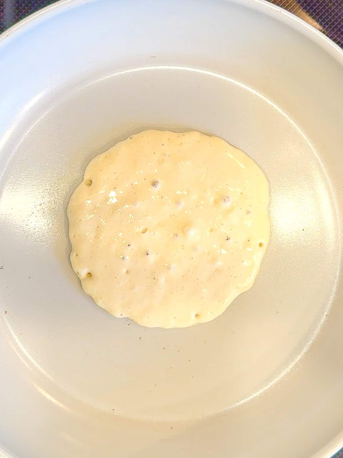 Pancake and a nonstick pan waiting to be flipped.