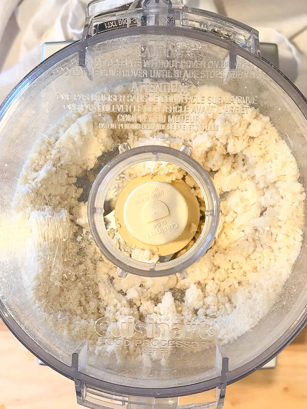 A cream cheese crust being made in a food processor.