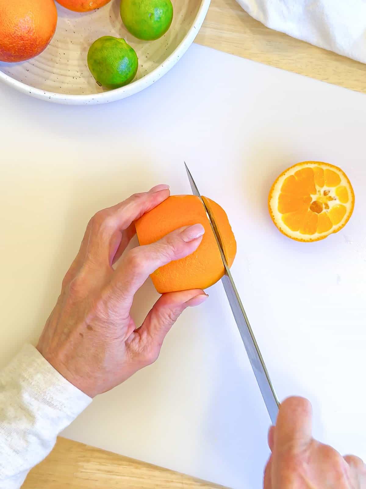 Slicing the ends off of an orange.