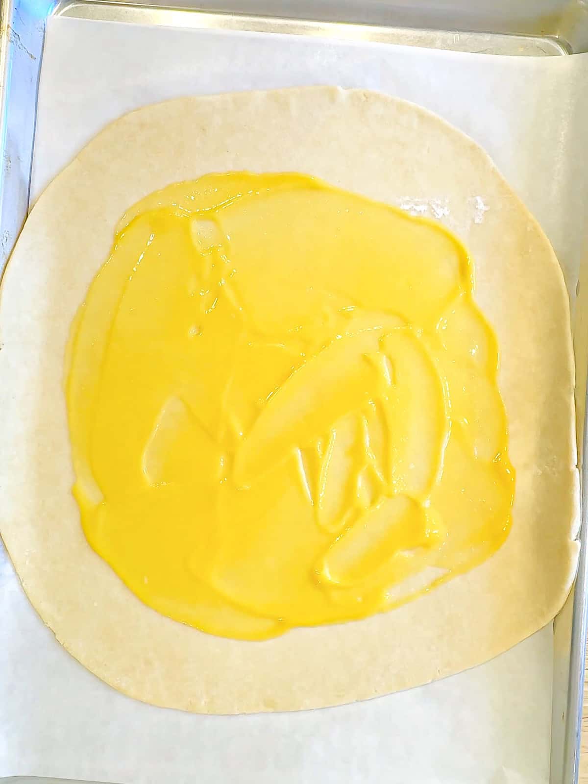 Lemon curd spread on a cream cheese crust.