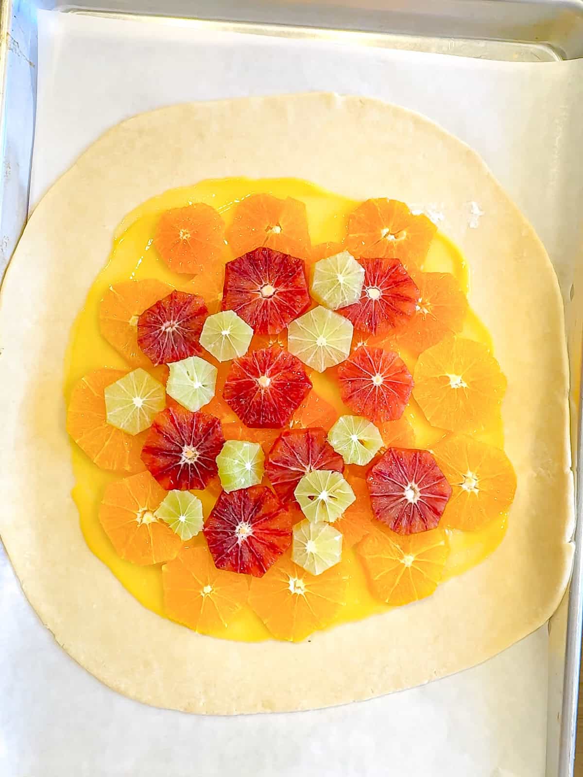 Artistically placed slices of citrus fruits on lemon curd with a cream cheese crust.