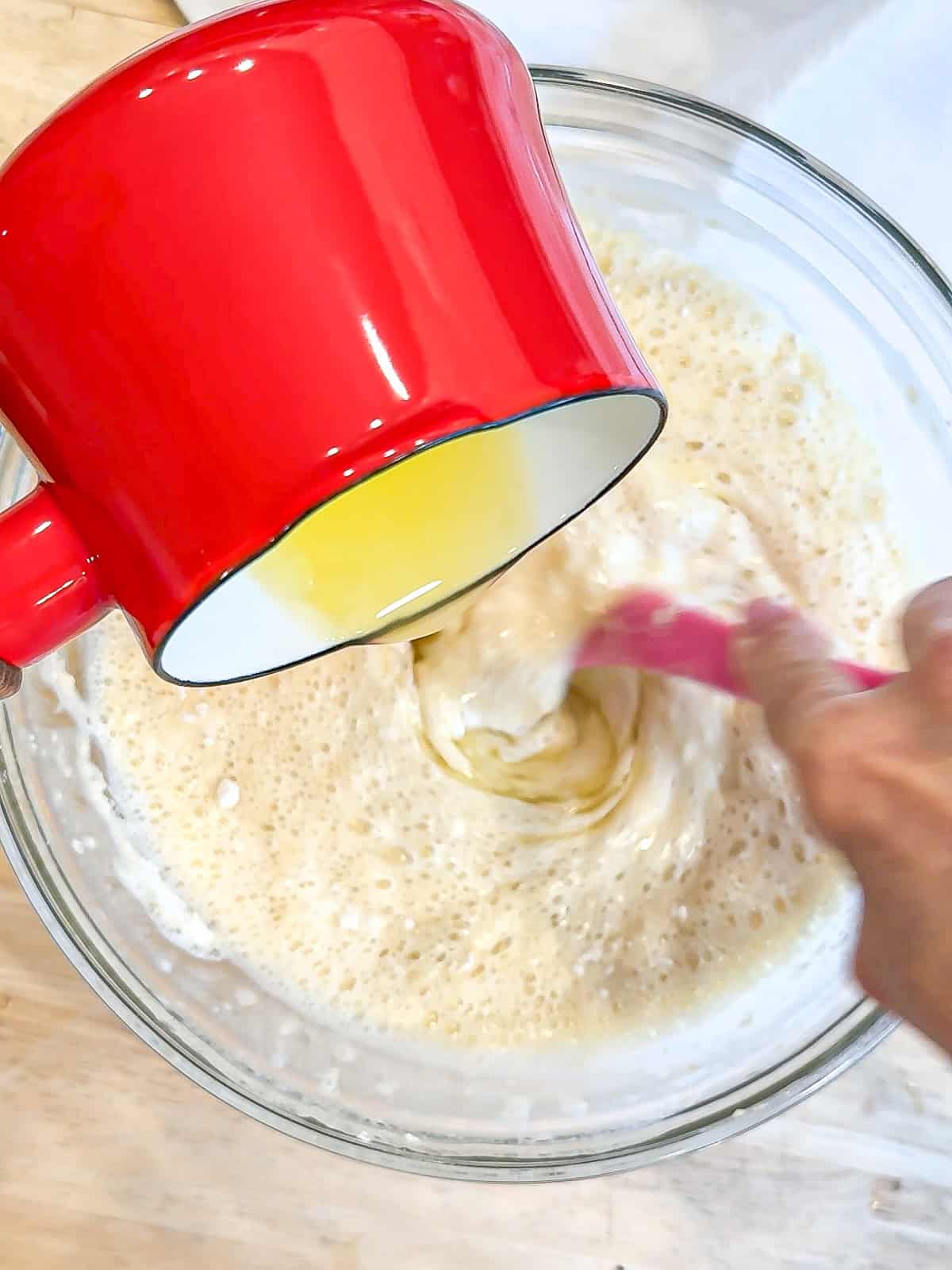 Adding melted and cooled butter into waffle batter.