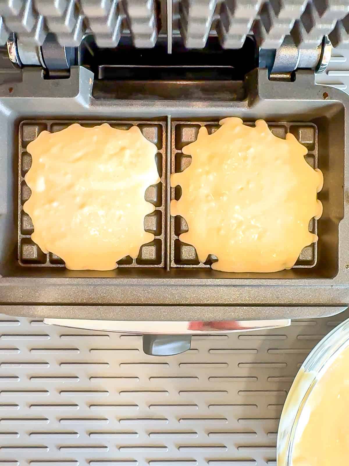 Uncooked waffle batter in a waffle iron.