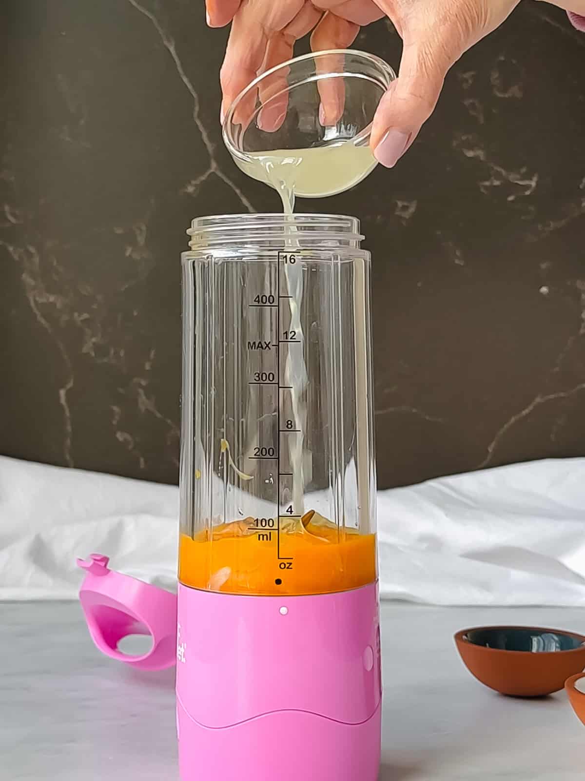 Adding ingredients into a personal blender to make hollandaise sauce.
