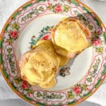 Eggs Benedict with hollandaise sauce on a floral plate.