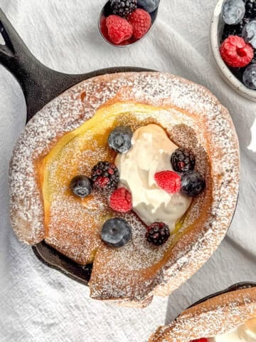Top view of a mini Dutch baby pancake with cream and fruit.