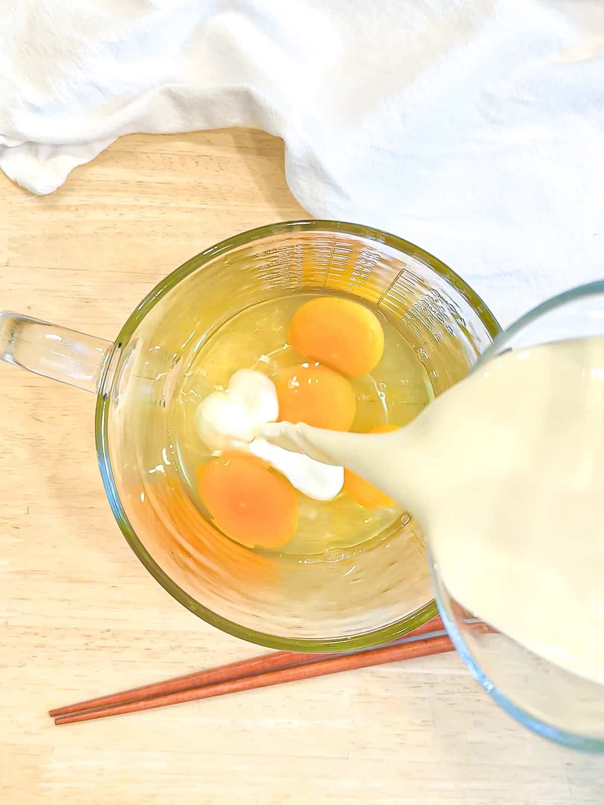 Adding half-and-half two eggs in a measuring cup.