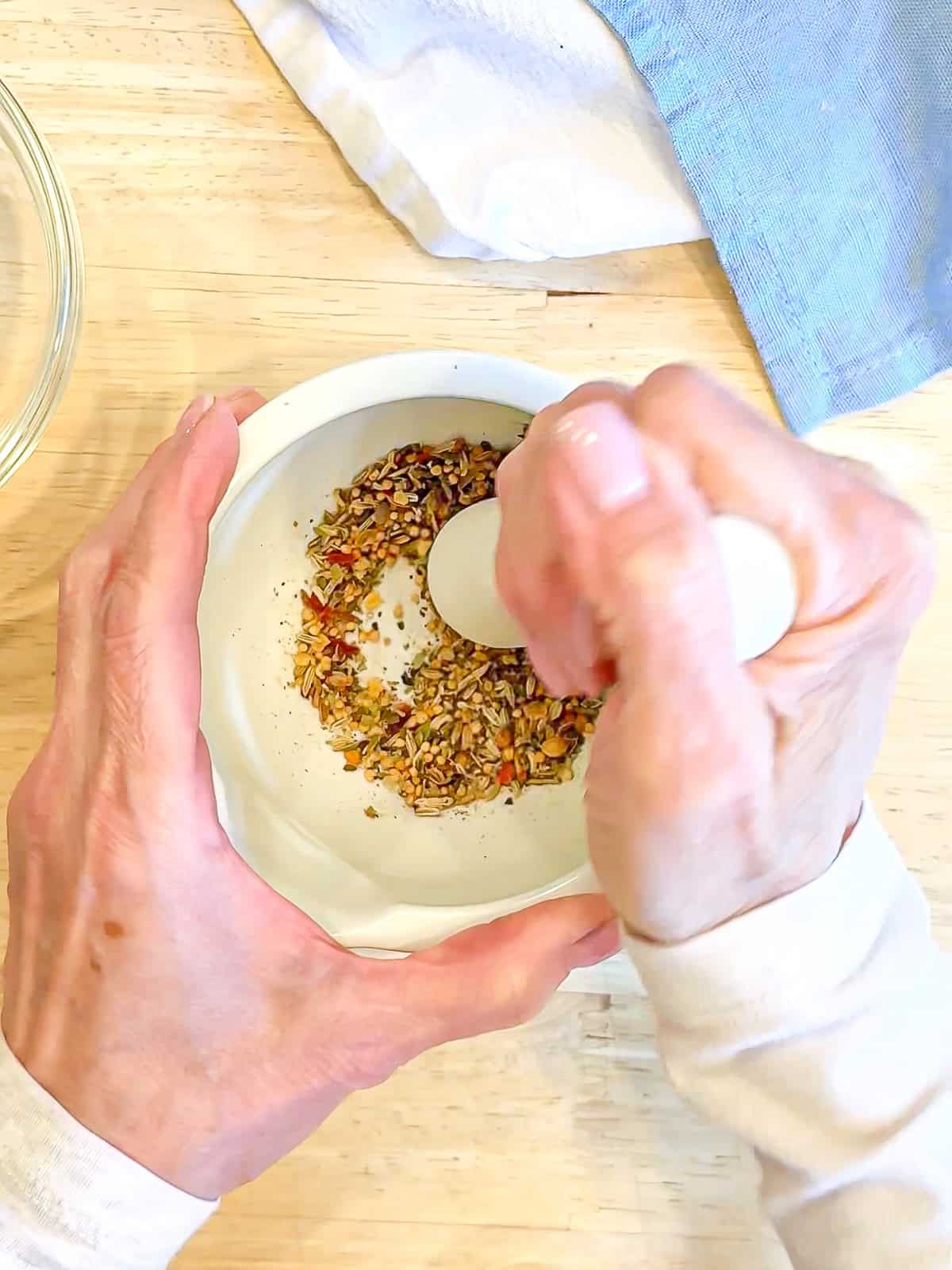 Crushing spices with a mortar and pestle.