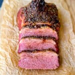 Sliced crispy corned beef on a wooden cutting board.