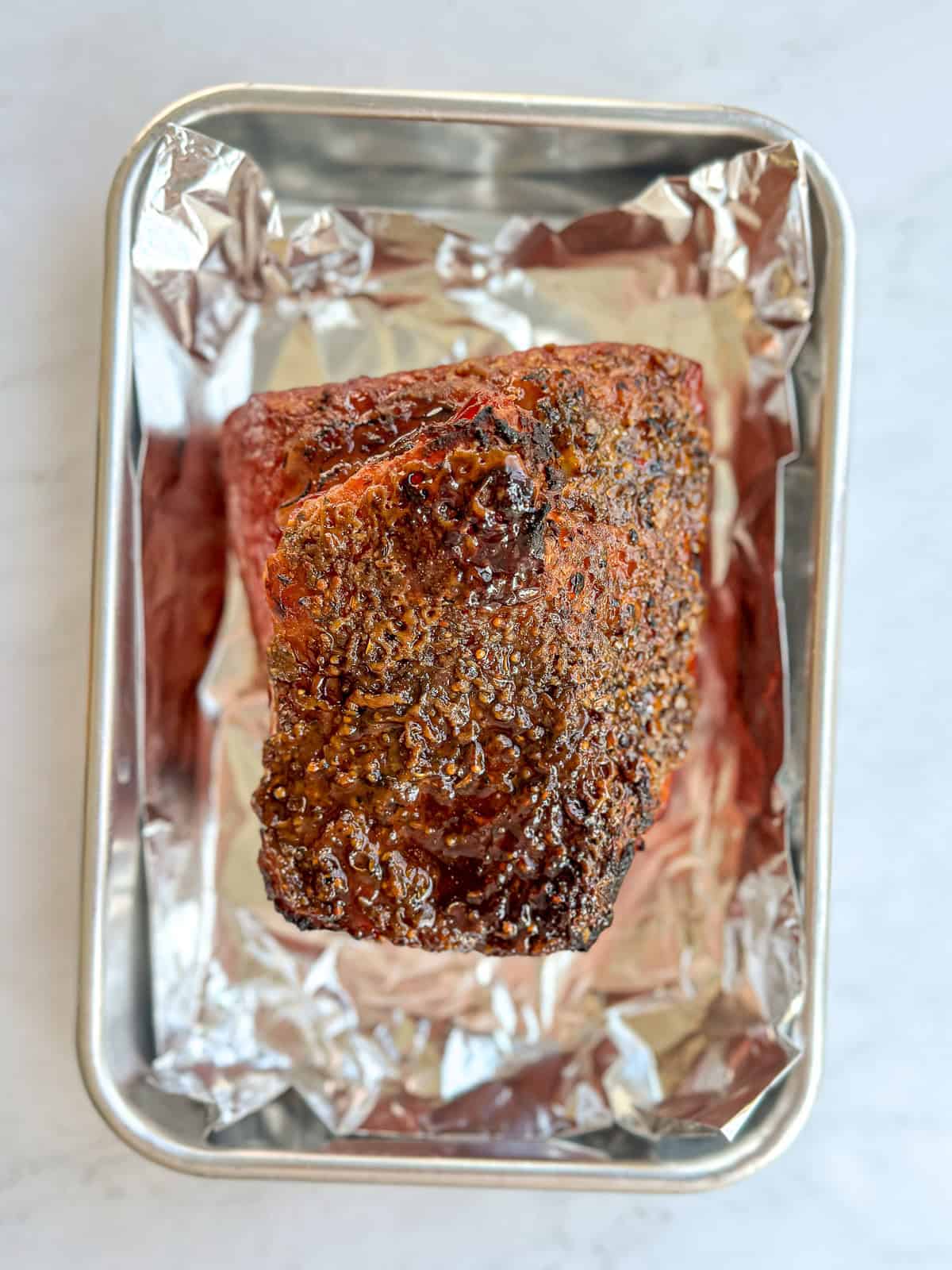 A corned beef in a foil lined sheet pan to go under the broiler for crisping.