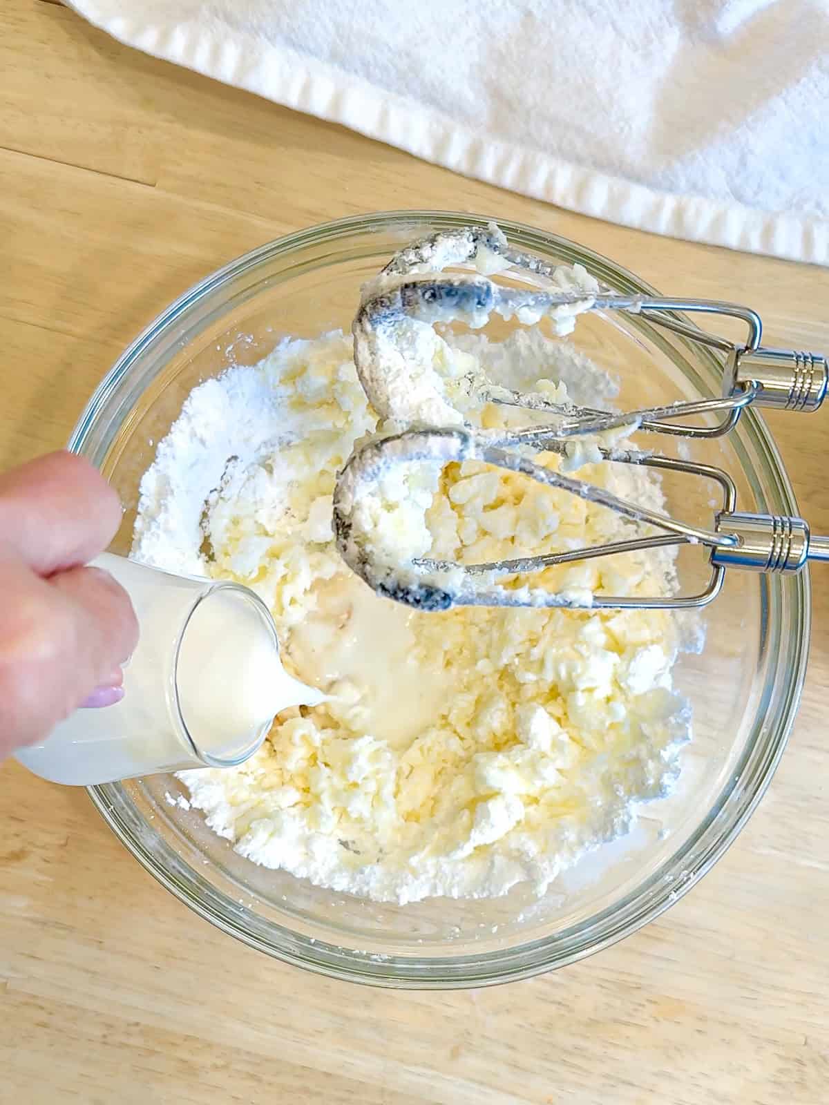 Adding a splash of milk to make cream cheese frosting.