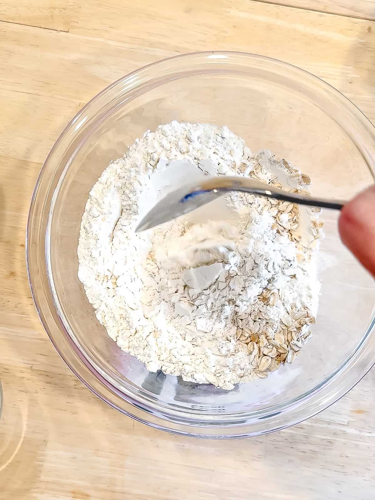 Folding together dry ingredients to make banana breakfast cake.