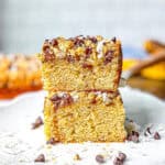 Two squares slices of banana cake on a white plate.