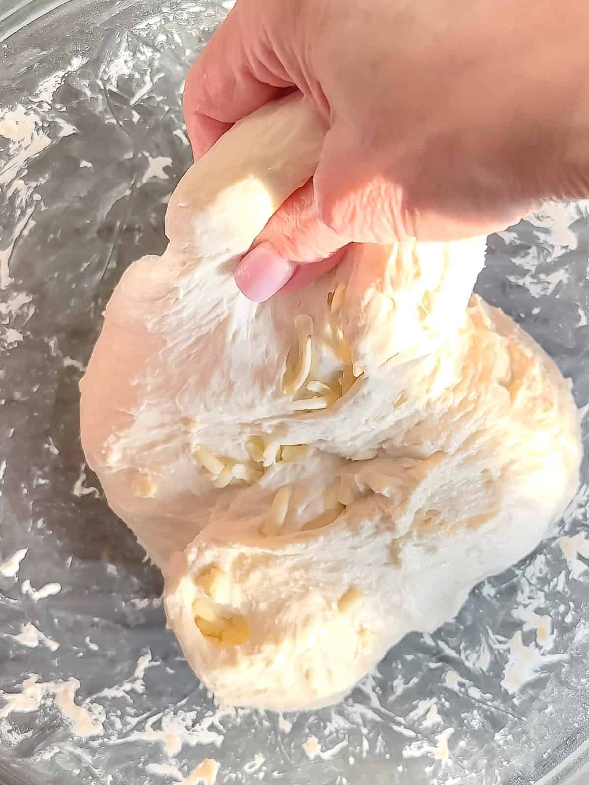 Bringing the side of dough down over the butter to enclose it while making laminated dough.