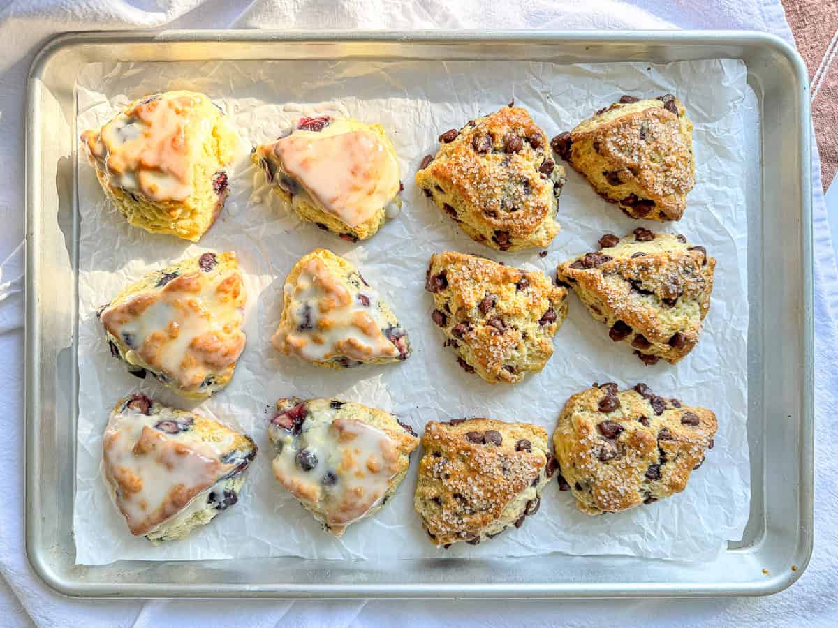 Blueberry and chocolate chip buttermilk scones on a paper lined sheet pan.