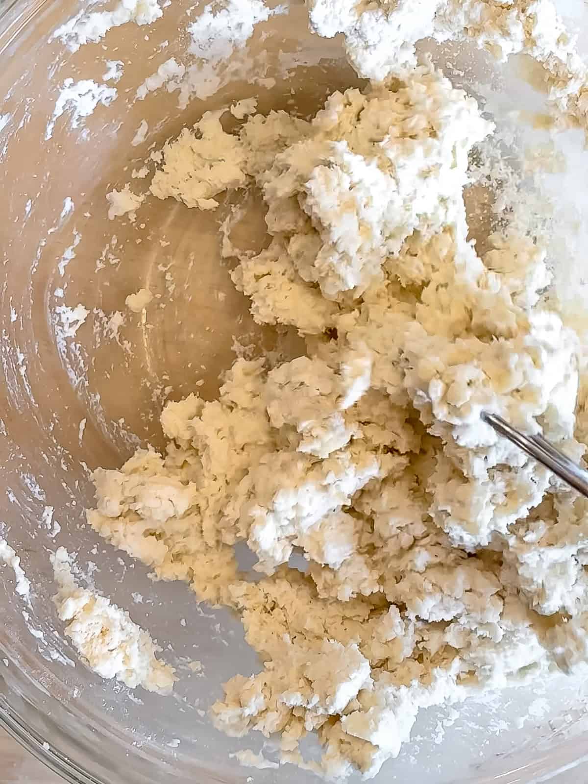 Mixed biscuit dough in a glass bowl.