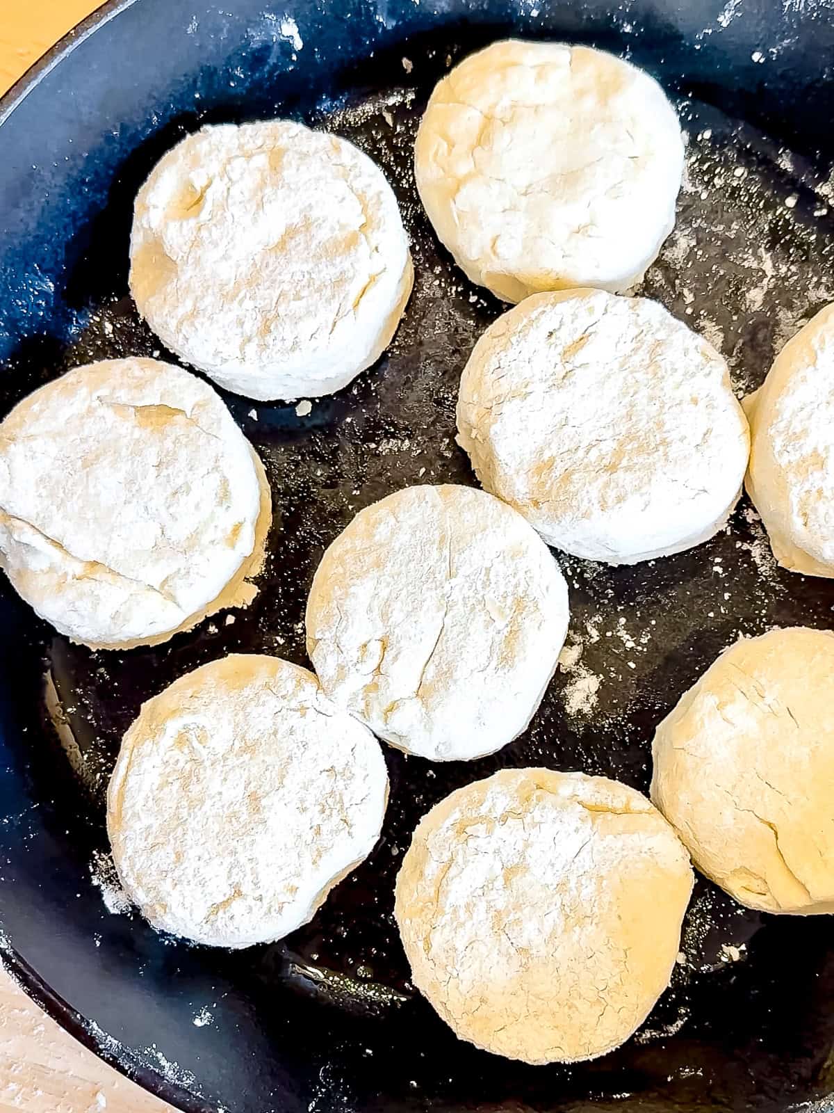 Unbaked biscuits in a cast iron pan.
