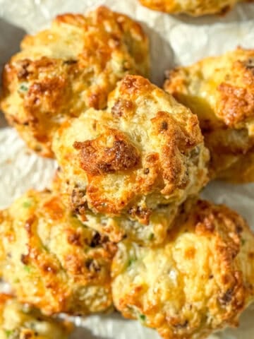 Cheese and sausage drop biscuits on parchment paper.