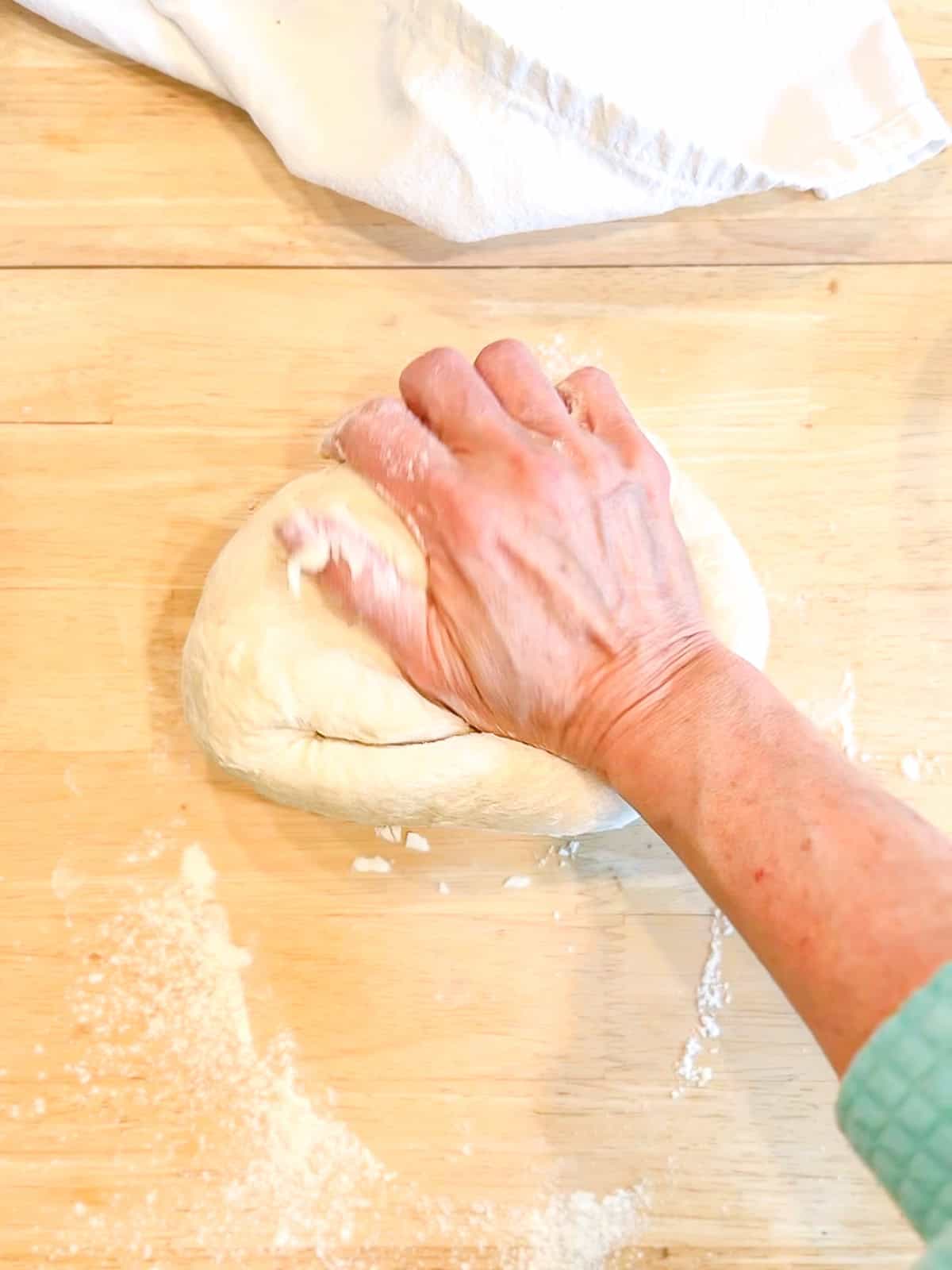Kneading dough on a wooden counter.