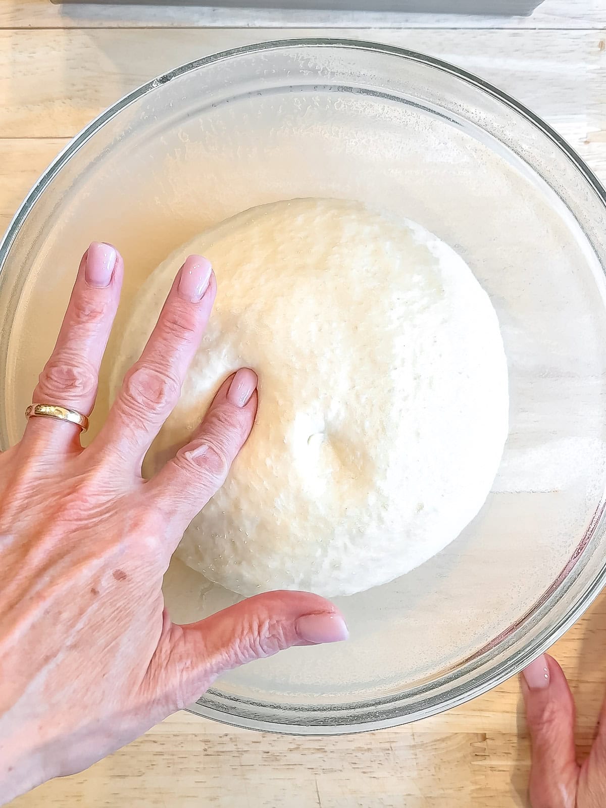 Poking a ball of dough to test for being done rising.