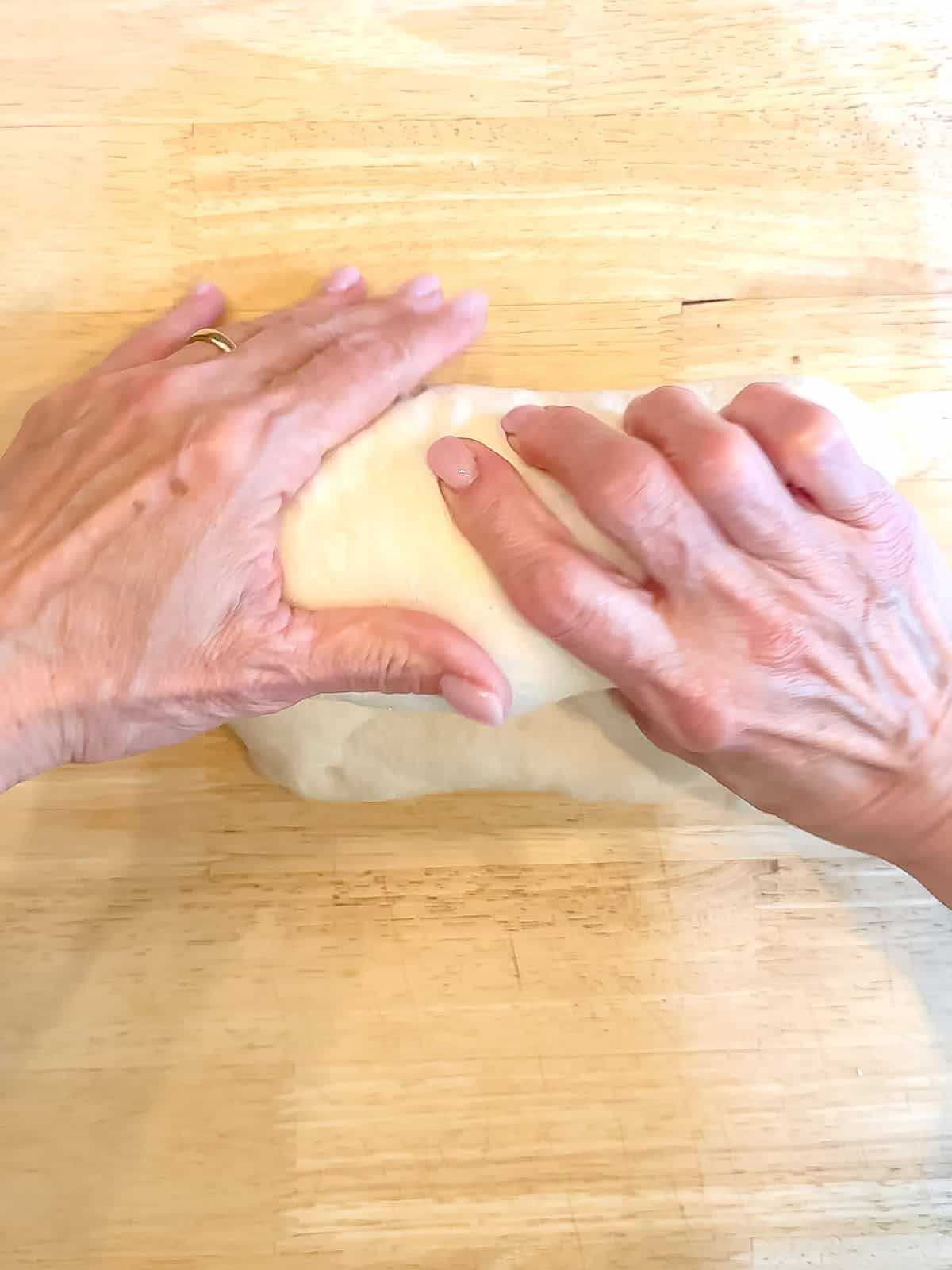Rolling dough into a loaf shape.