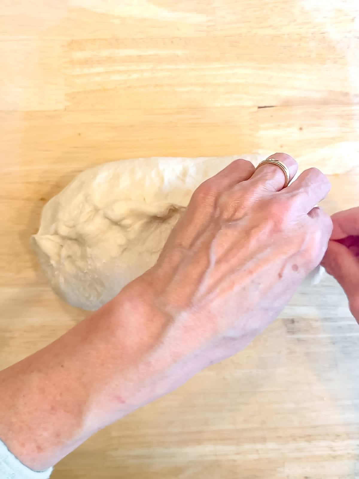 Pinging the seam shut on a loaf of bread dough.