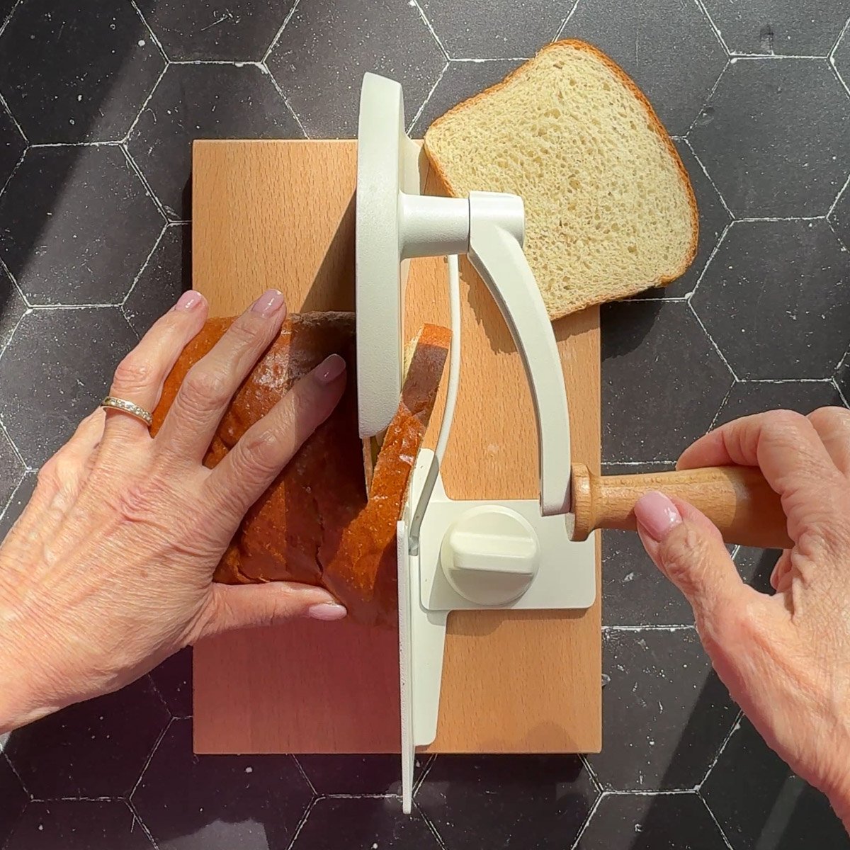 Slicing bread with a manual bread slicer.