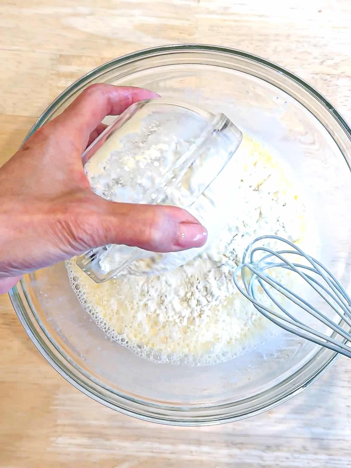Adding self rising flour to wedding ingredients to make pancake batter.