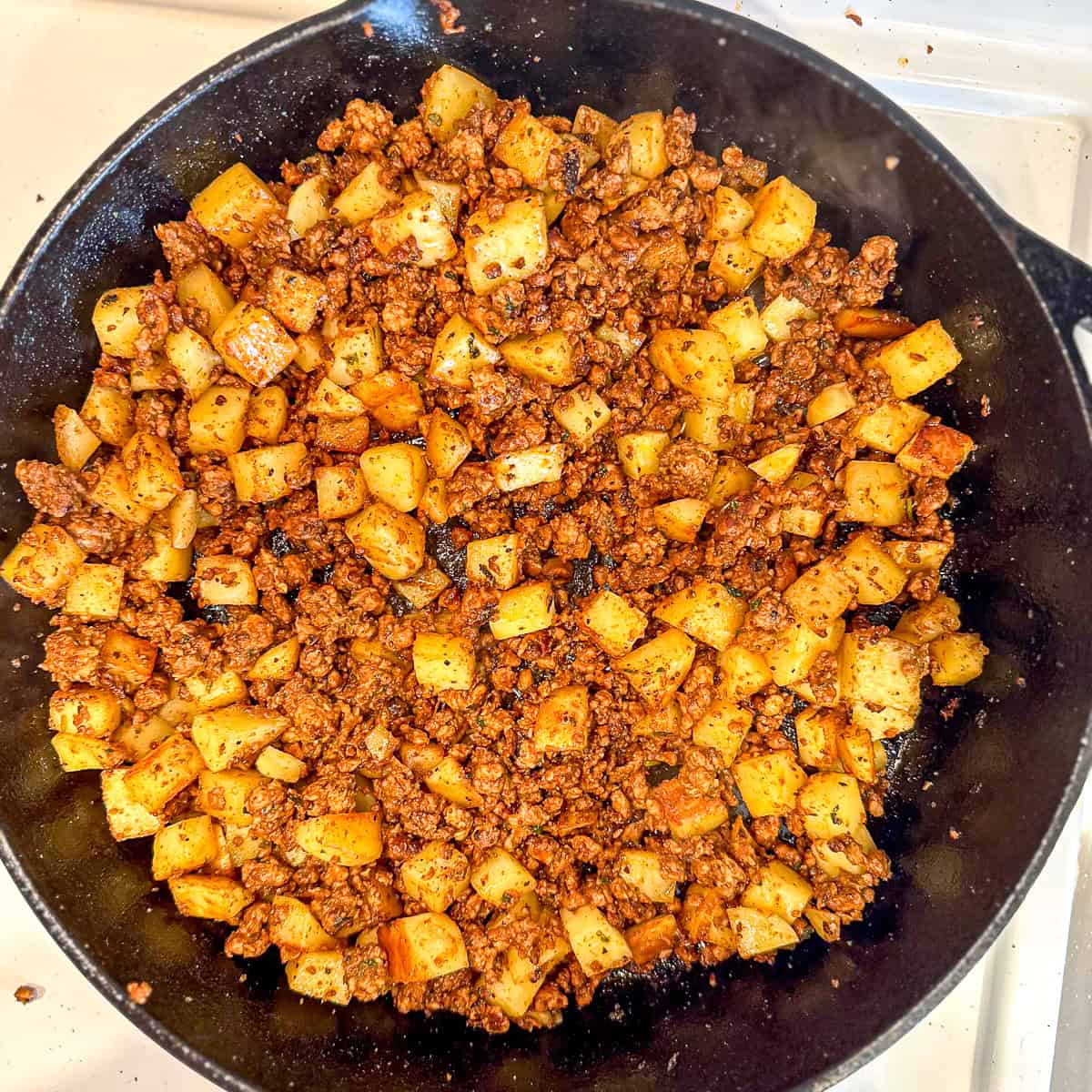 Homemade chorizo and potatoes cooked in a cast-iron pan.